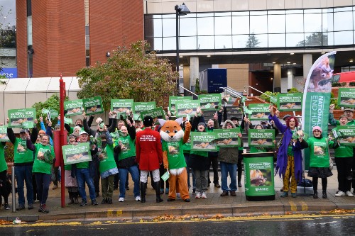 A large group of campaigners holding placards and wearing green tshirts