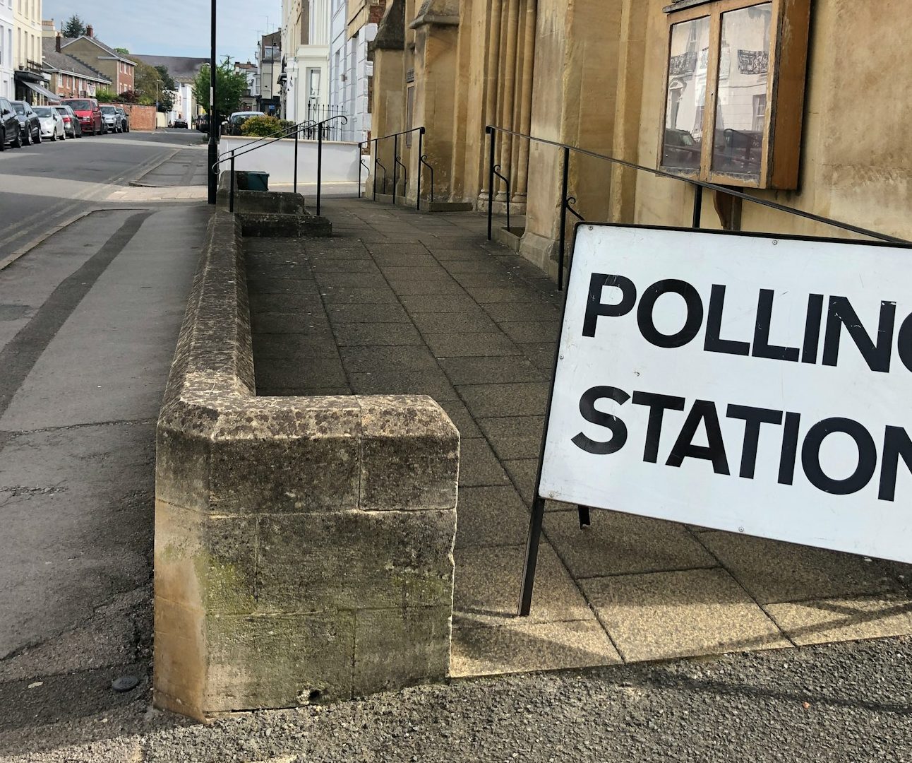A propped up sign reading 'polling station' in front of a sandstone building