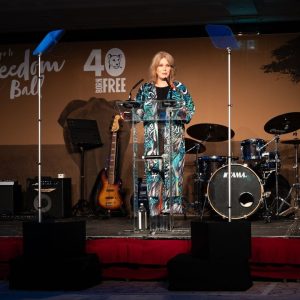 Dame Joanna Lumley standing on the stage giving a speech at the 2024 Footsteps to Freedom gala.