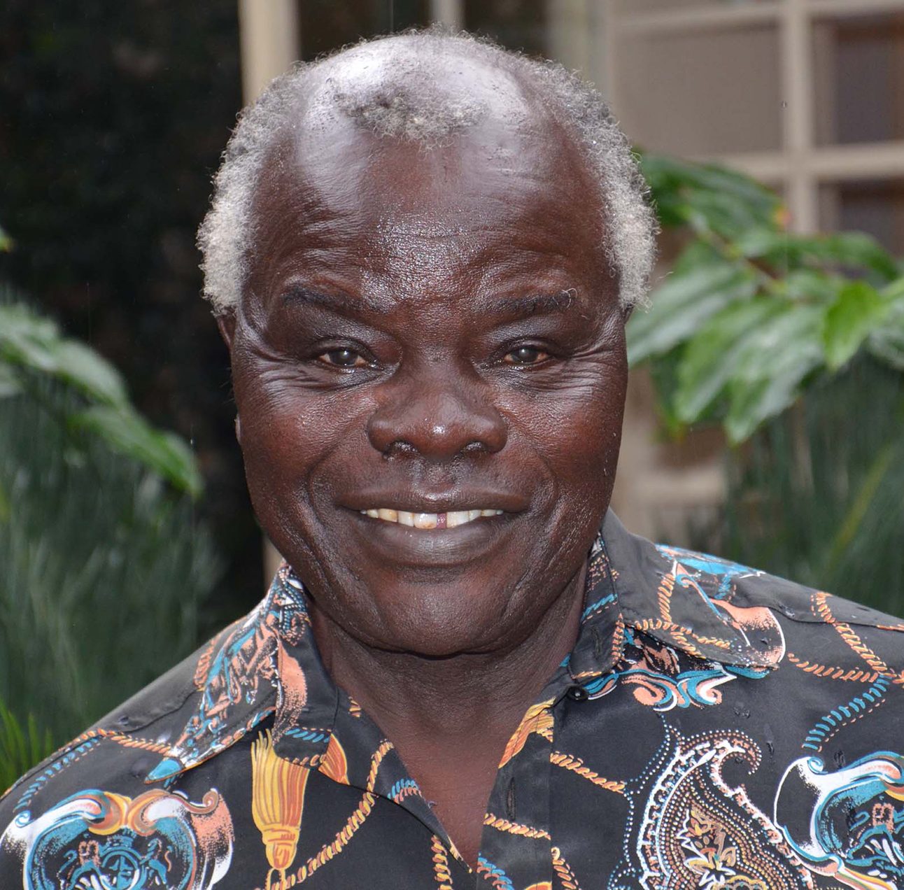 Head and shoulders photo of a smiling Dr Perez Olindo