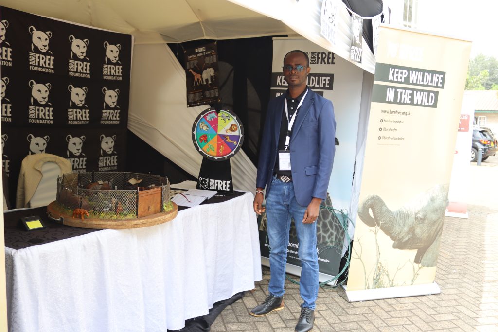 Newton Simiyu, Programme Manager, Saving Meru’s Giants, standing in front of Born Free’s exhibition