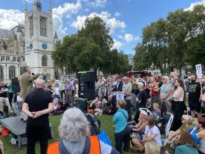 A large crowd of people are stood in Parliament Square, while Born Free's Dominic Dyer stands on stage