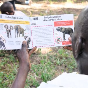 A man holding an 'elephant toolkit' booklet