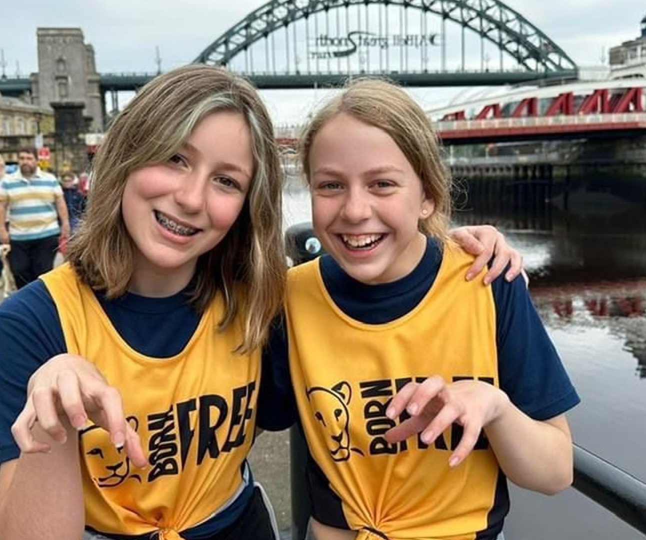 Two young girls wearing Born Free running vests, shown with their arms around each other