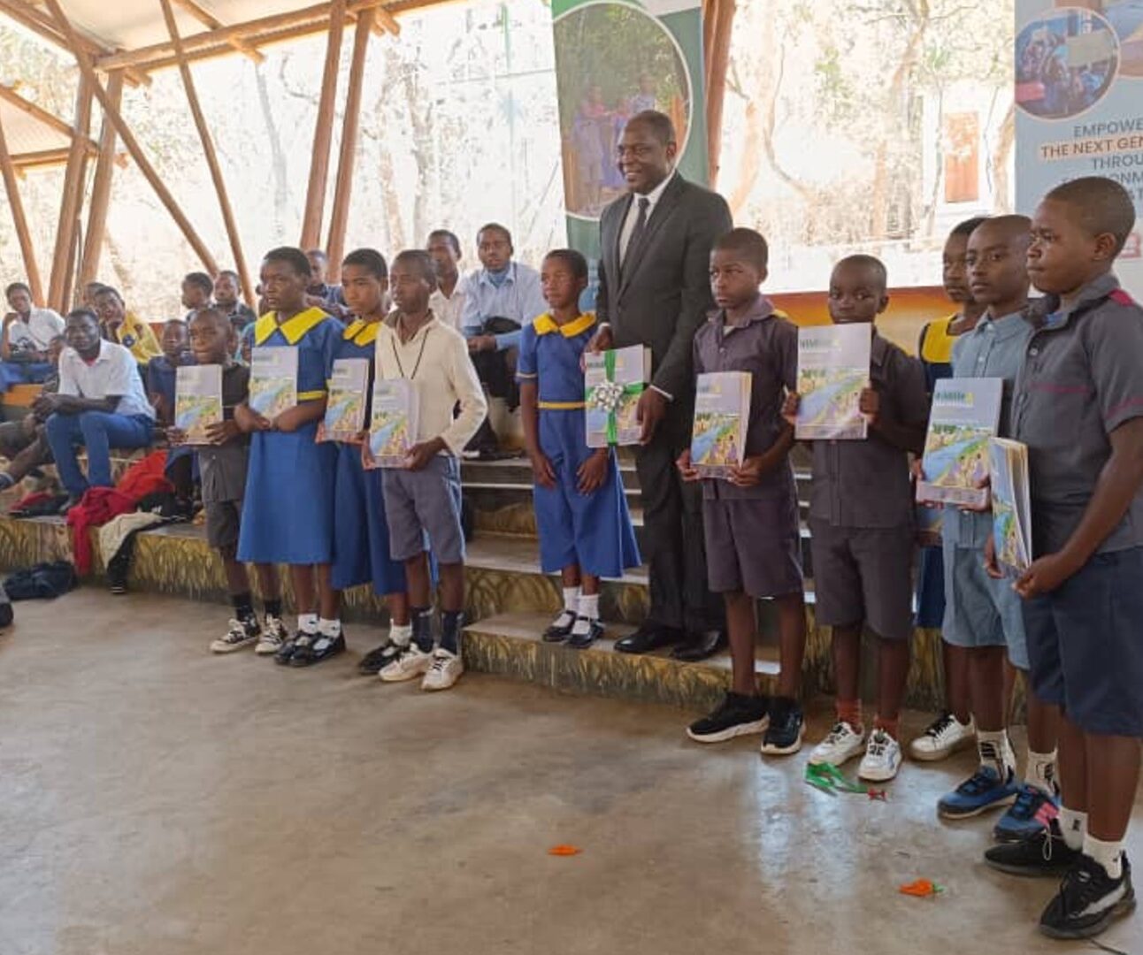 A group of school children in Malawi, holding up certificates